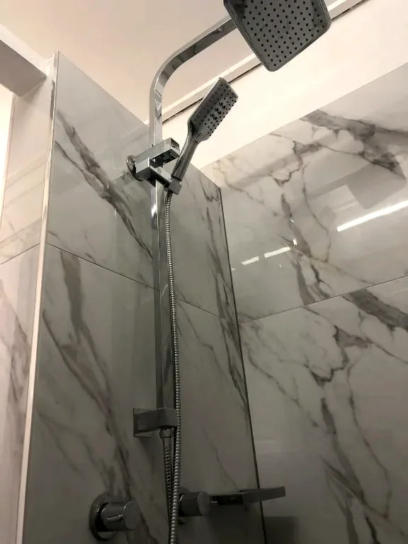 Private bathroom with a marble-tiled walk-in shower