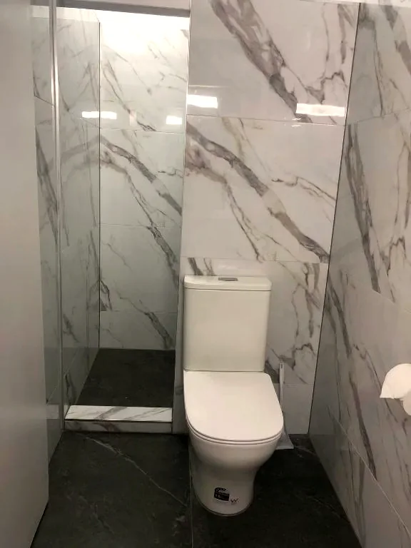Private marble-tiled bathroom with a walk-in shower