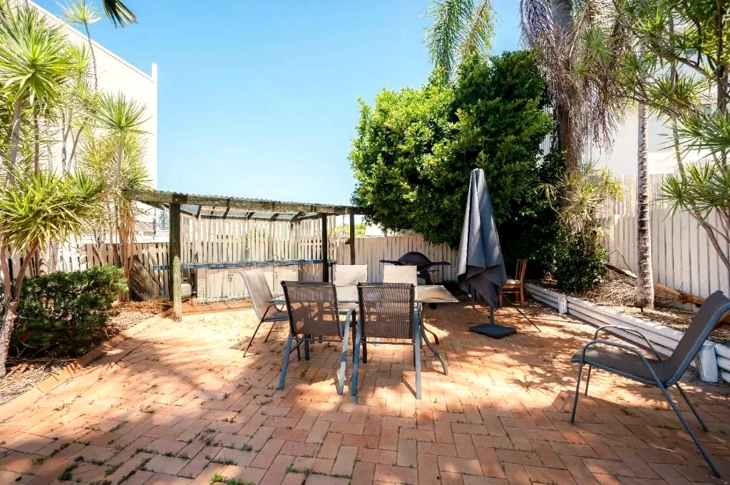 Courtyard with outdoor seating, a pergola and BBQ area in the motel grounds